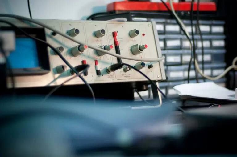 Test equipment panel with knobs and cables in an electronics lab