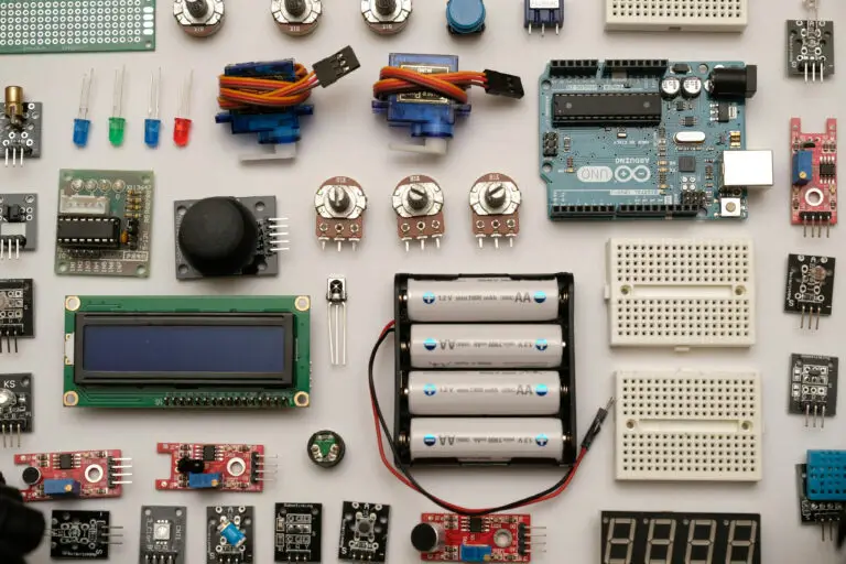 Electronic modules, potentiometers, batteries and an LCD laid out on a workbench